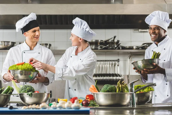 Chef multiculturali allegri che cucinano alla cucina del ristorante — Foto stock