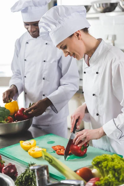 Chef cutting bell peppers at restaurant kitchen — Stock Photo
