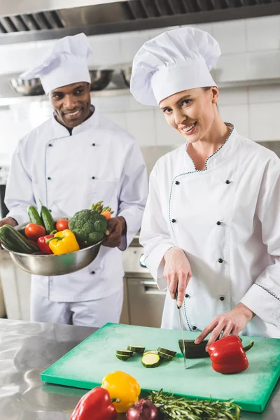 Cozinhando chefs multiculturais sorridentes na cozinha do restaurante — Fotografia de Stock