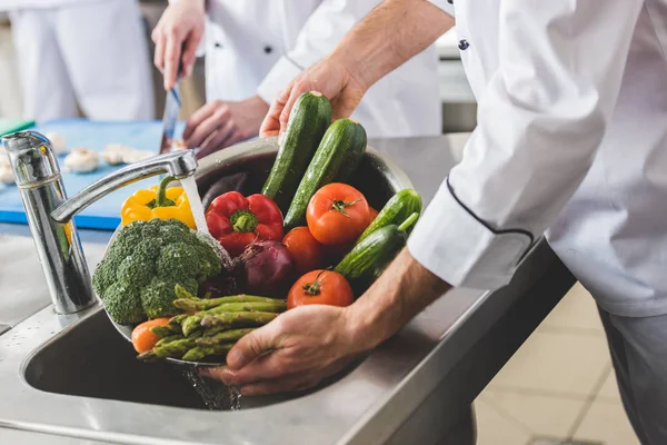 Imagem cortada de legumes de lavagem do chef na cozinha do restaurante — Fotografia de Stock