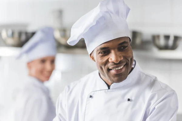 Chefs multiculturais sorridentes na cozinha do restaurante — Fotografia de Stock