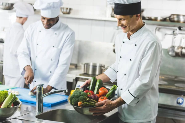 Glückliche multikulturelle Köche in der Restaurantküche — Stockfoto