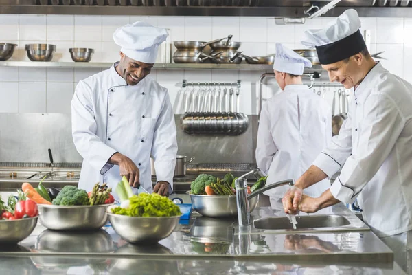 Cuochi multiculturali che cucinano nella cucina del ristorante — Foto stock