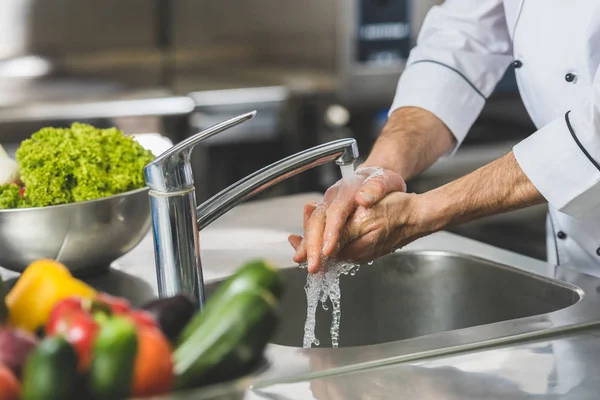Обрезанный образ мытья рук шеф-поваром на кухне ресторана — стоковое фото