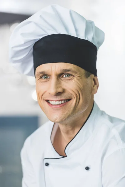 Retrato del guapo chef sonriente en la cocina del restaurante - foto de stock