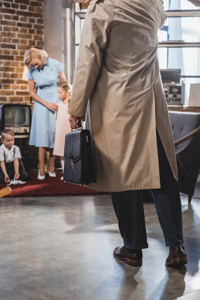 Schnappschuss von Vater mit Aktentasche, der nach Hause kommt, während glückliche Familie zusammen spielt, 50er-Jahre-Stil — Stockfoto