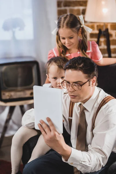 1950s style family using digital tablet at home — Stock Photo