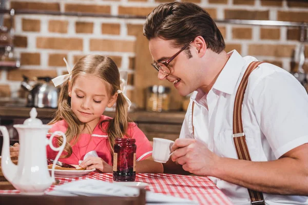 Glücklicher Vater und süße kleine Tochter beim gemeinsamen Frühstück, Familie im Stil der 1950er Jahre — Stockfoto