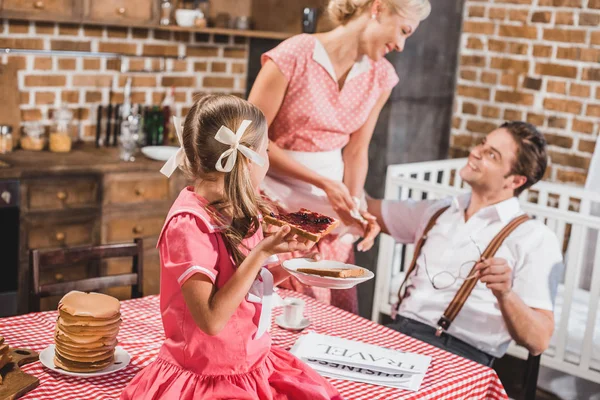 Padres felices con un niño pequeño y lindo desayunando juntos, al estilo de los años 50 - foto de stock