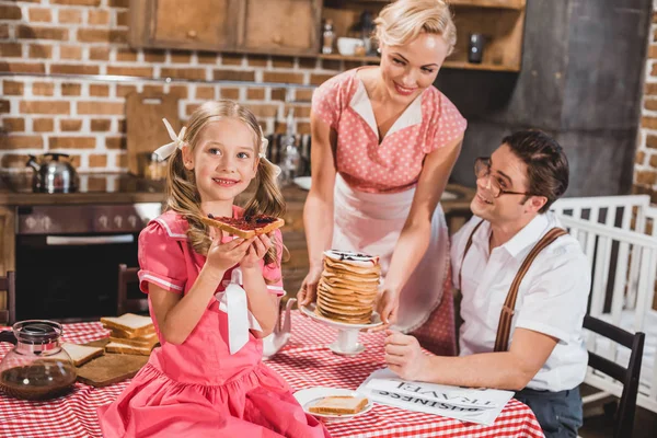 Glückliche Eltern mit entzückender kleiner Tochter beim gemeinsamen Frühstück im Stil der 1950er Jahre — Stockfoto