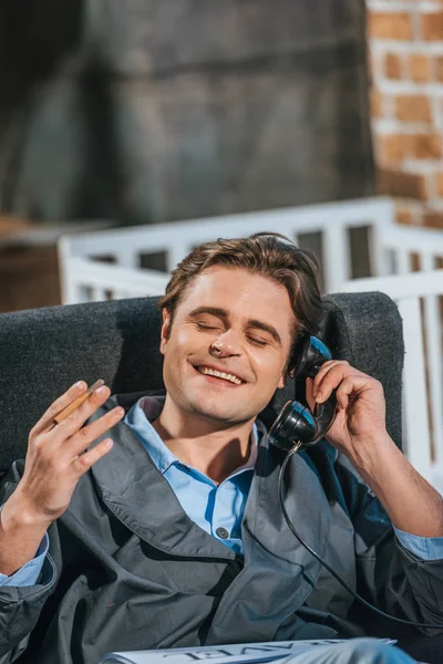 Happy man in robe smoking cigarette and talking by vintage telephone — Stock Photo