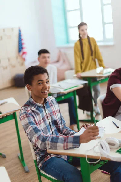 Studenti adolescenti multietnici seduti in classe — Foto stock