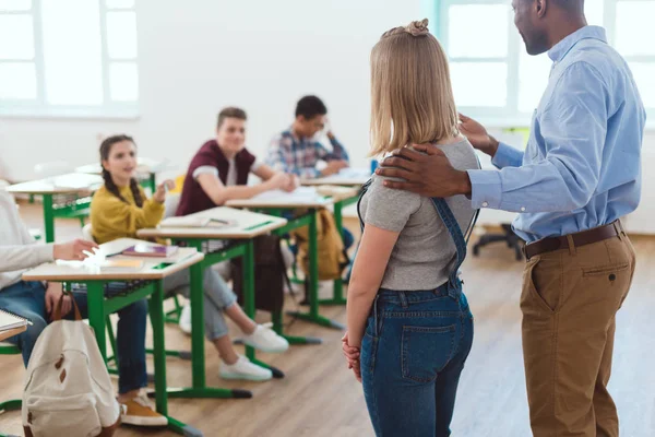 African american teacher introducing new girl to multicultural classmates — Stock Photo