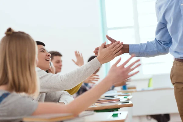 Cropped image of african american teacher taking high five to high school students — Stock Photo