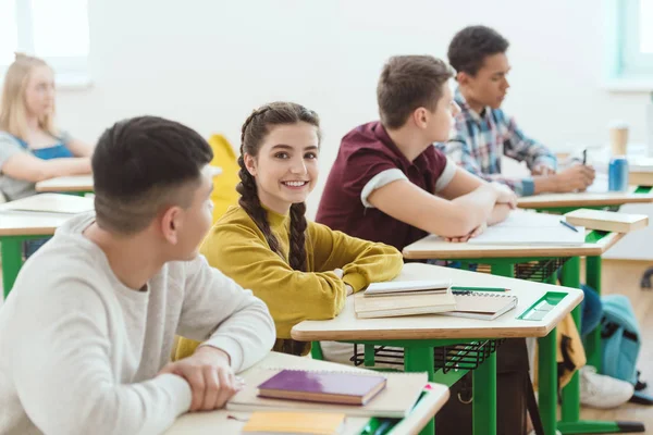 Fila de estudiantes de secundaria sentados en clase durante la lección - foto de stock