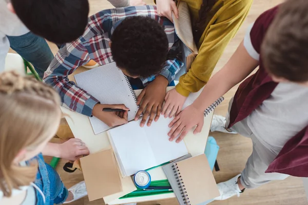 Top view of high school students helping their classmate with homework — Stock Photo