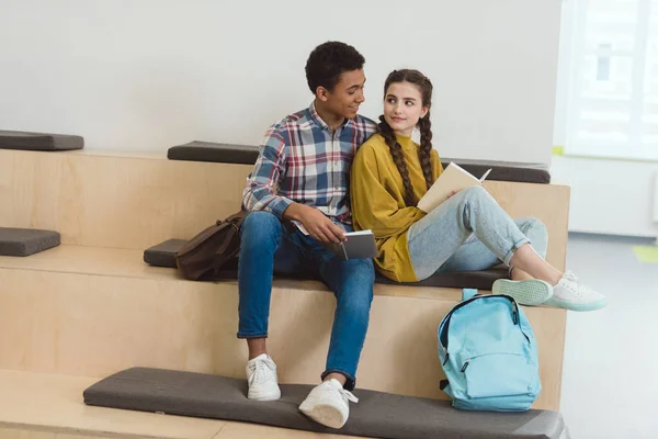 Studenti delle scuole superiori coppia che studiano insieme nel corridoio scolastico — Foto stock