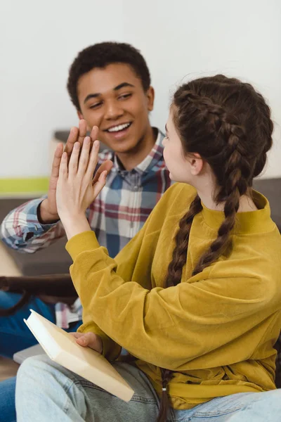 Estudiantes de secundaria pareja dando alta cinco - foto de stock