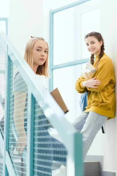 Adolescentes écolières debout sur les escaliers et regardant la caméra — Photo de stock