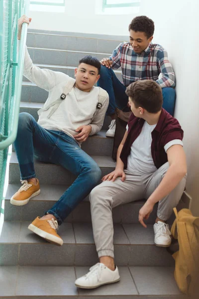 Teenage schoolboys sitting on stairs at school — Stock Photo