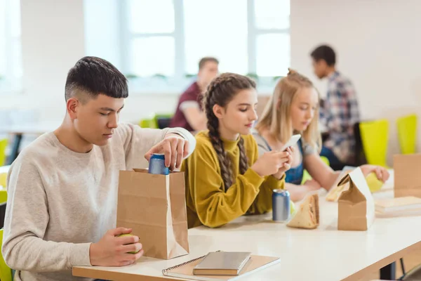 Adolescentes estudiantes de secundaria en la cafetería de la escuela durante el almuerzo - foto de stock
