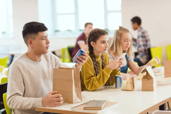 Grupo de estudiantes de secundaria en la cafetería de la escuela juntos - foto de stock