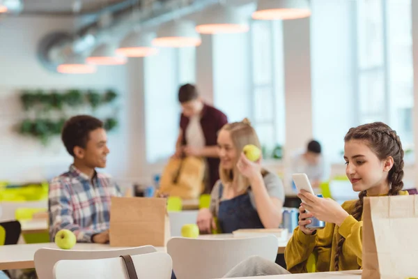 Les élèves du secondaire passent du temps à la cafétéria de l'école pendant le déjeuner — Photo de stock