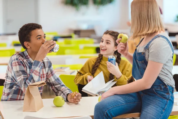 Élèves du secondaire prenant le déjeuner ensemble à la cafétéria de l'école — Photo de stock