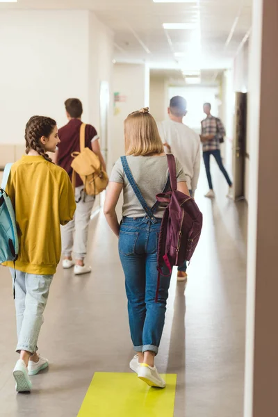 Vista posteriore degli studenti delle scuole superiori che camminano lungo il corridoio scolastico — Foto stock