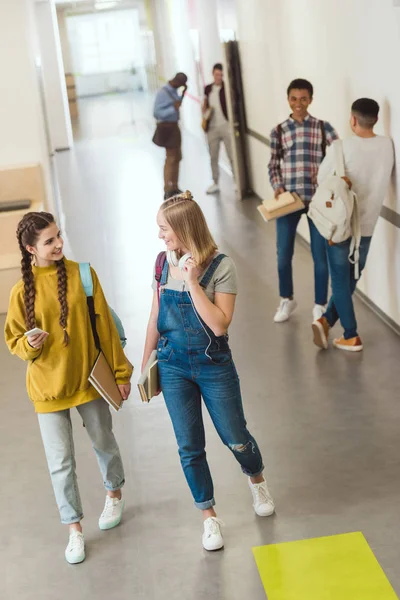 Группа мультиэтнических старшеклассников проводит время в школьном коридоре во время перерыва — стоковое фото