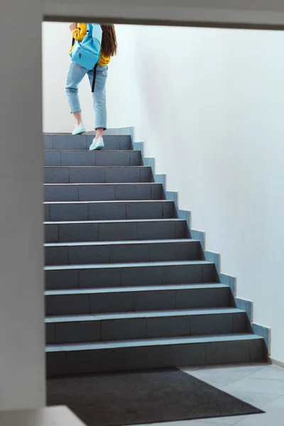 Rückansicht einer Schülerin, die im Schulflur nach oben geht — Stockfoto