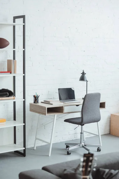 Interior de la sala de estar moderna con ordenador portátil en la mesa de trabajo - foto de stock