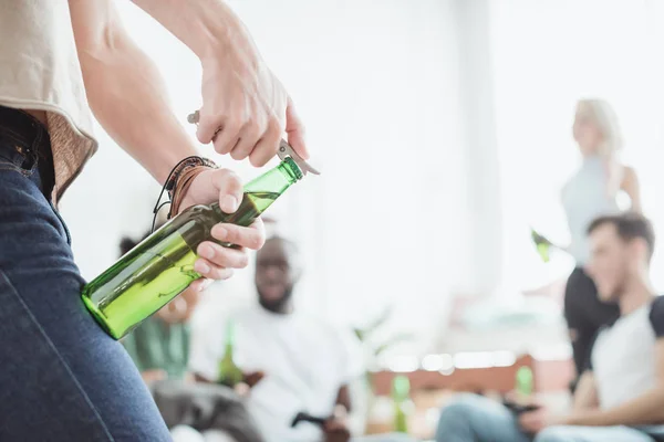 Cropped image of man opening beer bottle by corkscrew — Stock Photo
