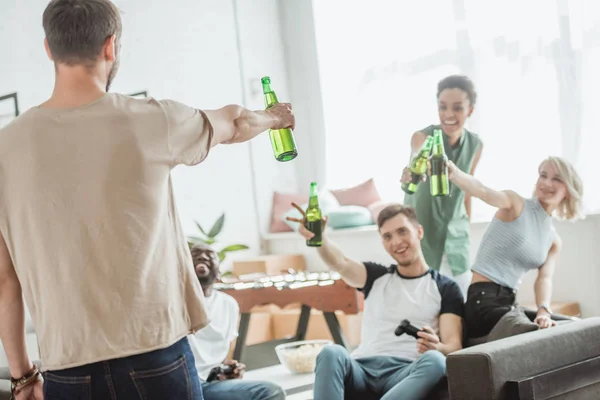 Vista posteriore del giovane con bottiglia di birra tifo con l'amico — Foto stock