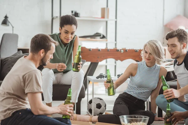 Group of young multiethnic friends cheering with bottles of beer — Stock Photo