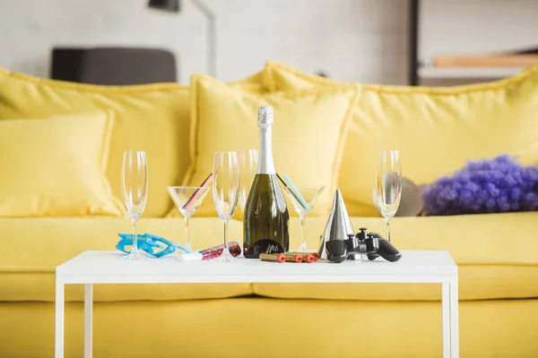 Gros plan de la table avec champagne, verres, joystick et fournitures de fête — Stock Photo