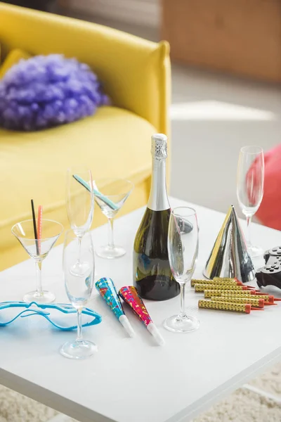 Champagne bottle and glasses on table with party hat — Stock Photo