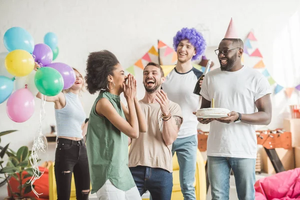 Happy young men and woman celebrating with birthday cake  on surprise party — Stock Photo