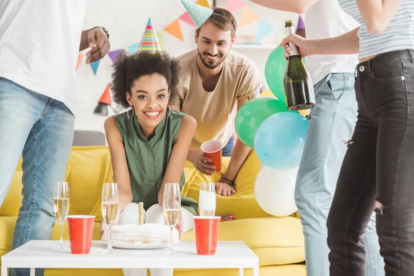 Happy young men and woman celebrating with champagne and birthday cake — Stock Photo