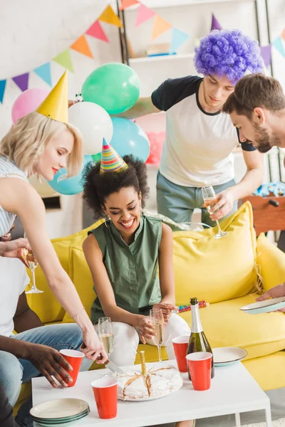 Hombres y mujeres celebrando con champán y pastel de cumpleaños - foto de stock