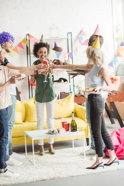 Jovens sorridentes brindam com champanhe na festa de aniversário — Fotografia de Stock