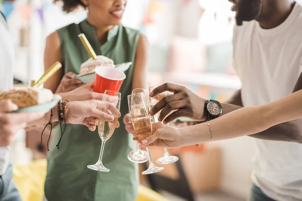 Молоді чоловіки і жінки тости з шампанським на вечірці на день народження — стокове фото