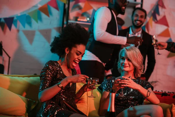 Young people celebrating with drinks in decorated room — Stock Photo