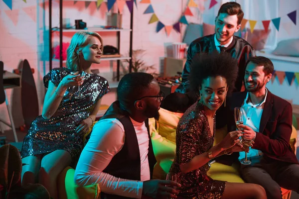 Multiracial smiling friends having party with drinks in decorated room — Stock Photo