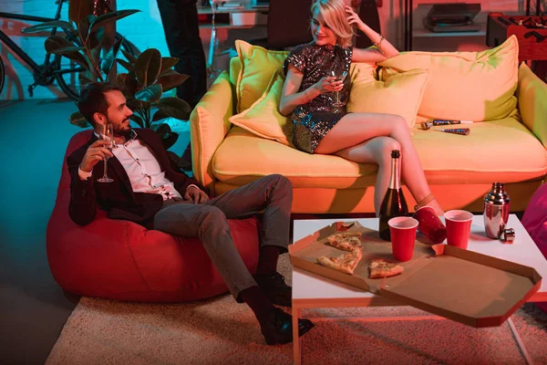 Glamorous man and woman holding glasses and relaxing at party — Stock Photo