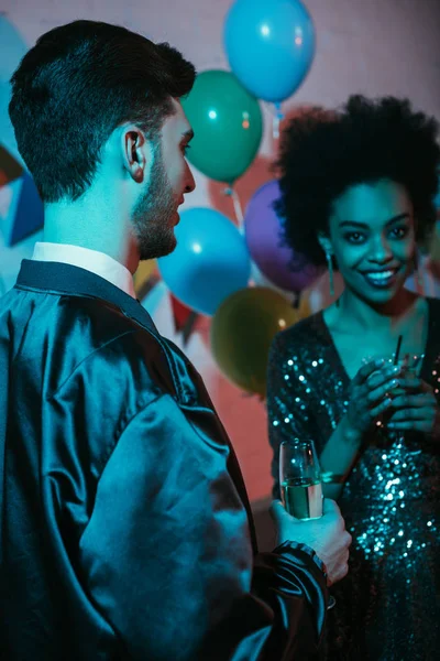 Man and woman holding glasses and talking at party — Stock Photo