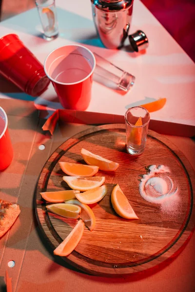 Top view of wooden board with oranges and party cups with drinks — Stock Photo