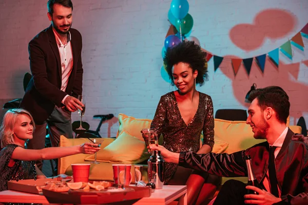 Amigos multirraciais fazendo festa com bebidas no quarto decorado — Fotografia de Stock