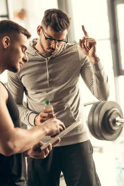 Bello sportivo mostrando idea gesto in palestra — Foto stock