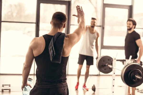 Beaux sportifs agitant les mains dans la salle de gym — Photo de stock